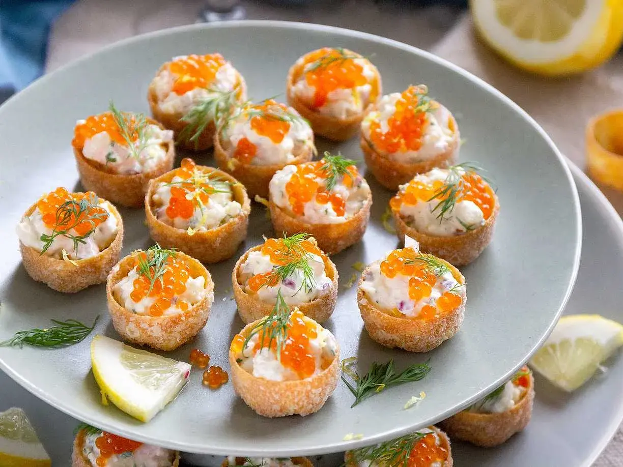 Små, krispiga krustader i ugn fyllda med en krämig röra och toppade med orange rom och dill. Perfekta för mingel!