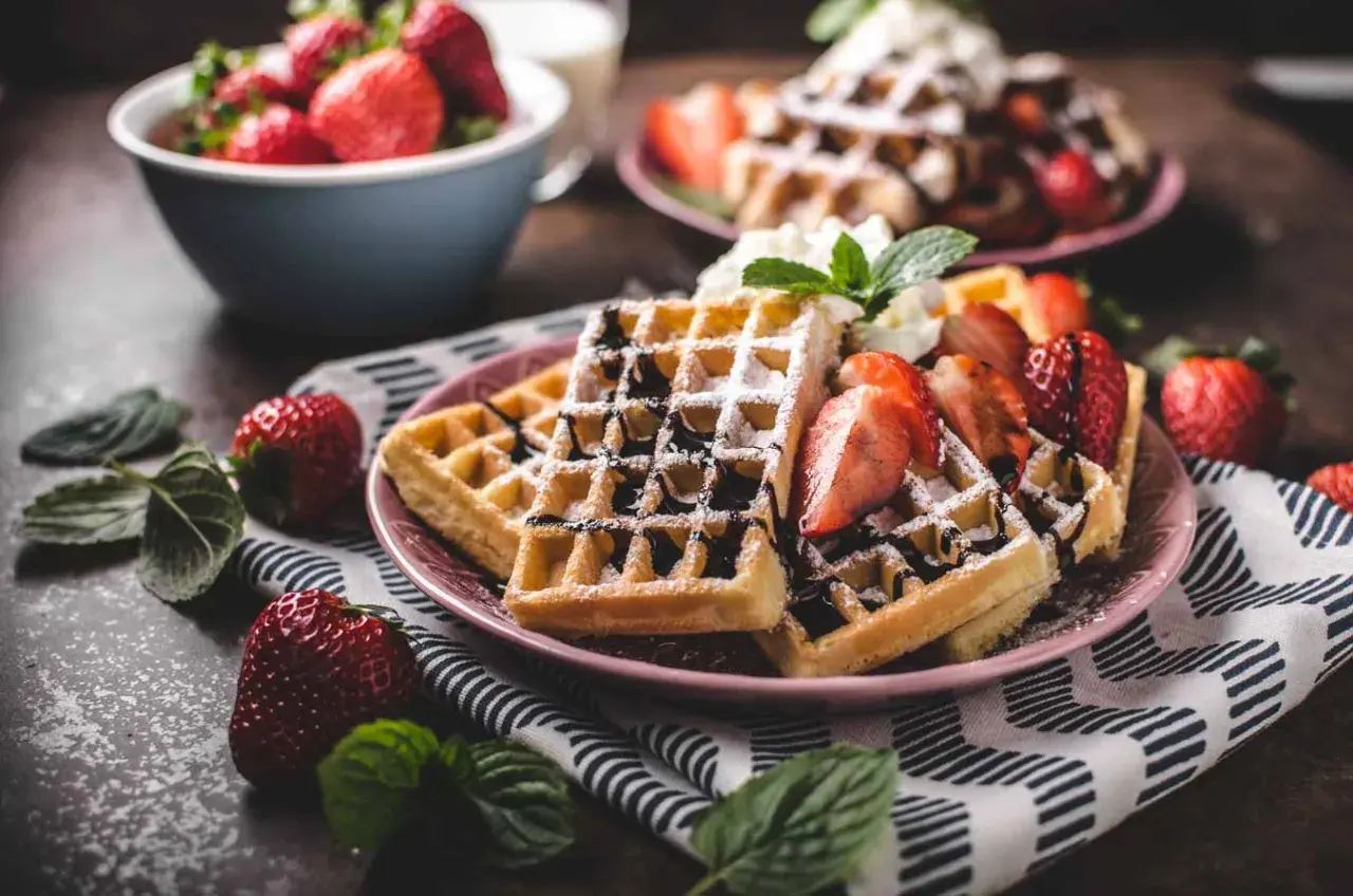 Belgiska våfflor recept: gyllene våfflor med färska jordgubbar, chokladsås och vispgrädde. En perfekt frukost eller dessert.