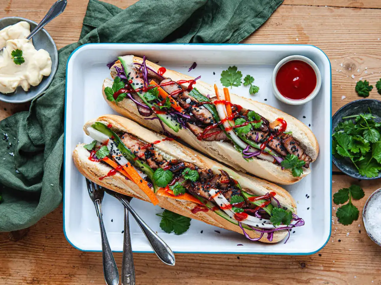 Tv&aring; l&auml;ckra banh mi med grillat k&ouml;tt, krispiga gr&ouml;nsaker och koriander. Serveras med chilidressing och majonn&auml;s.