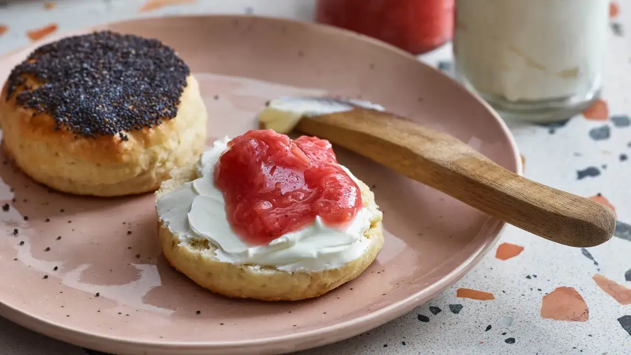 En skål med scones med vallmofrön och en annan med grädde och jordgubbssylt. Perfekt för en fika med scones med yoghurt.