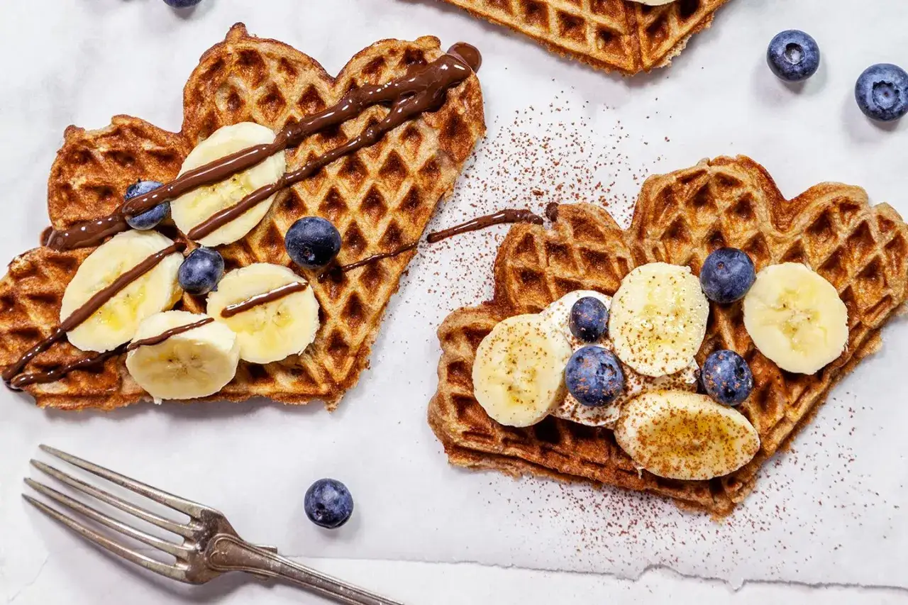 Hj&auml;rtformade v&aring;fflor med banan, bl&aring;b&auml;r och choklads&aring;s. Ett perfekt v&aring;fflor recept f&ouml;r en mysig frukost eller fika.