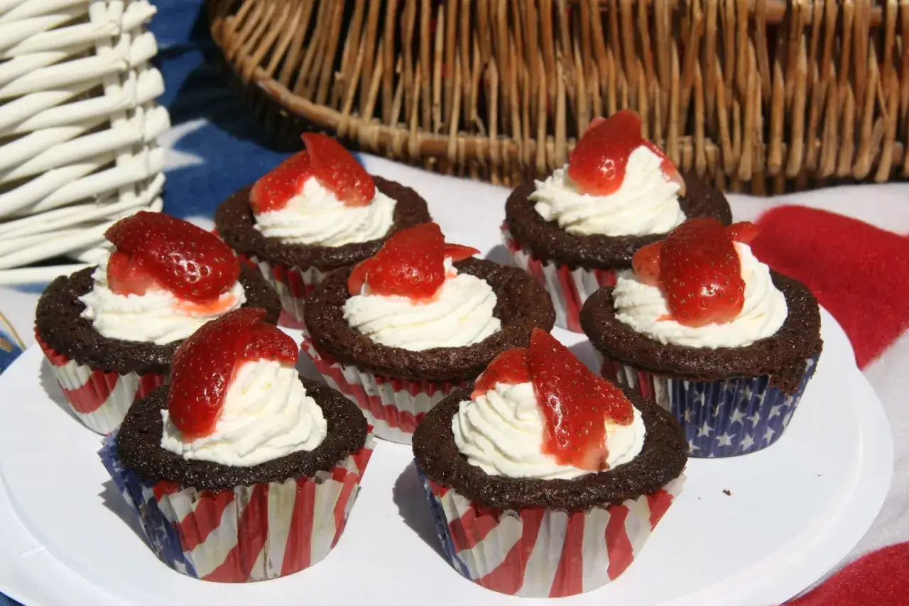 Kladdkakemuffins med grädde och jordgubbar, perfekta för sommarens firanden. Ett enkelt kladdkakemuffins recept.
