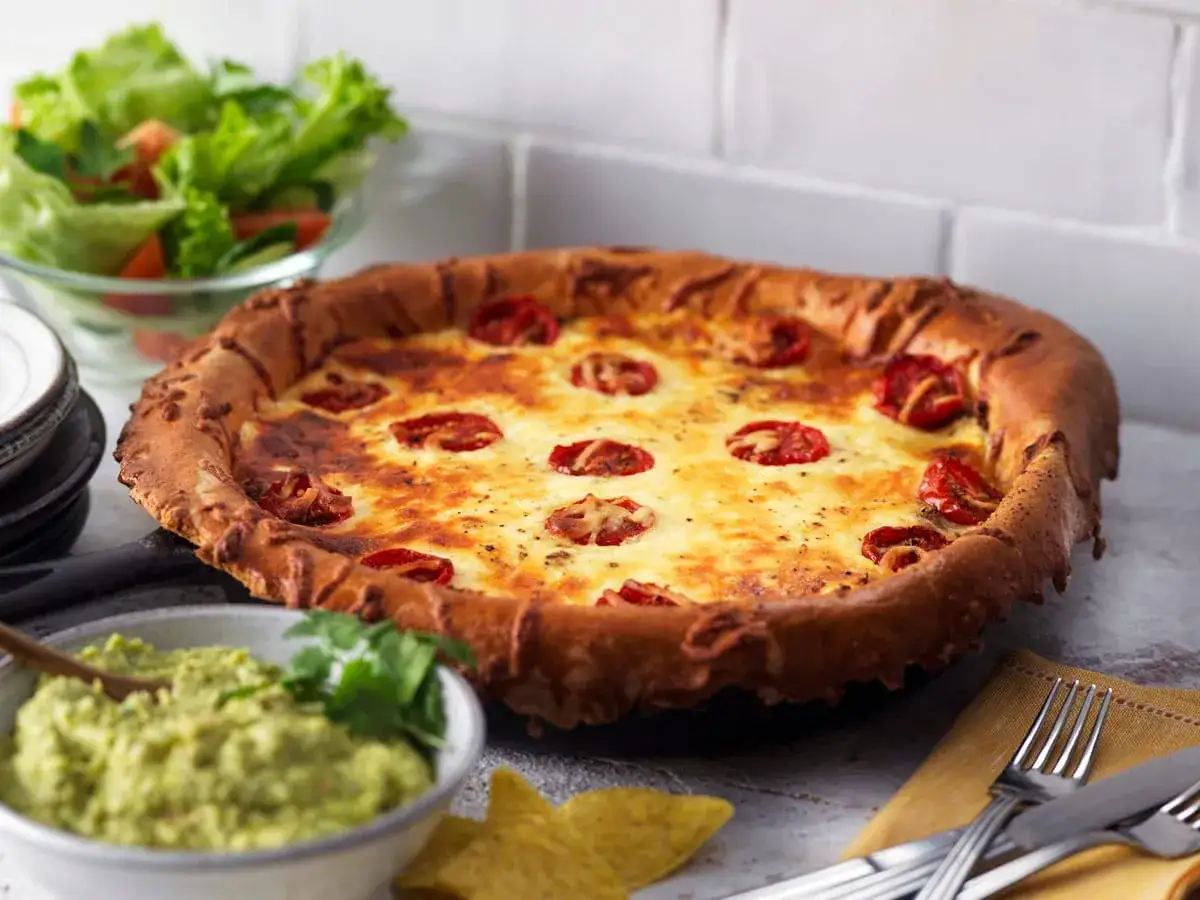En gyllene tacopaj med tomater och ost, serverad med guacamole och en fr&auml;sch sallad till. Perfekt sallad till tacopaj!
