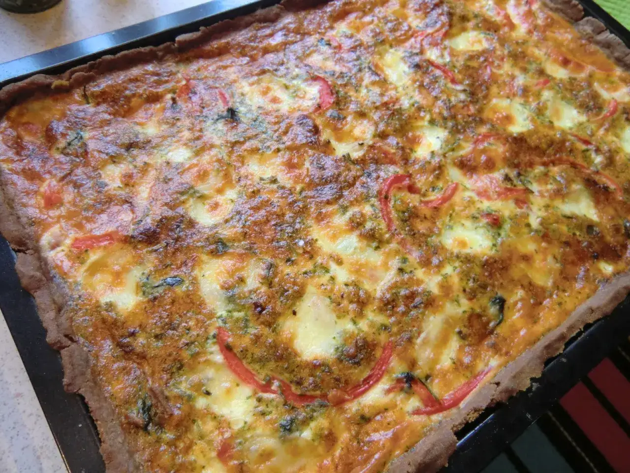 En stor, gyllene paj med ost och paprika, perfekt som paj till många.