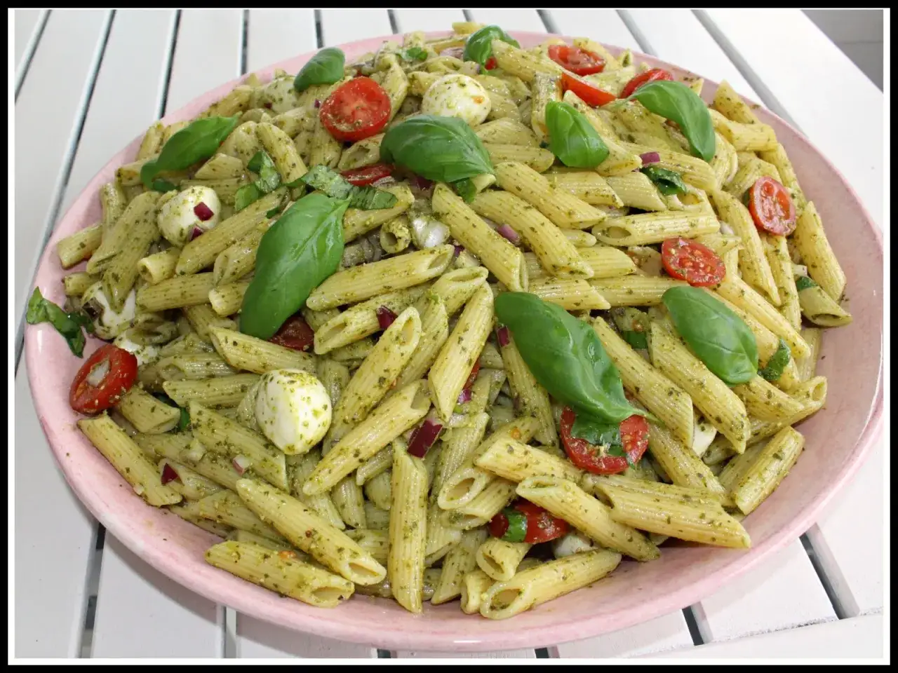 En stor sk&aring;l med pastasallad med penne, pesto, k&ouml;rsb&auml;rstomater, mozzarella och basilika. En perfekt pastasallad pesto f&ouml;r sommaren.