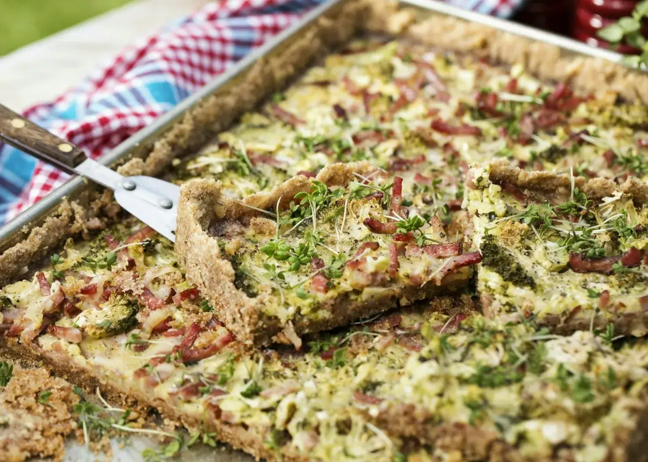 En gyllene kycklingpaj i långpanna, toppad med krispigt bacon och färska örter. Perfekt för en somrig picknick.