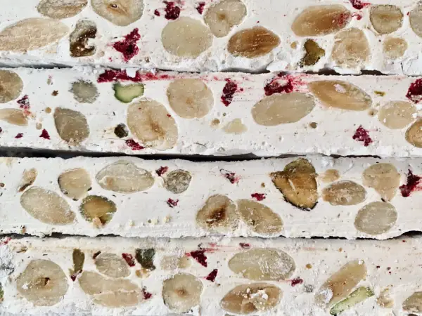 Nära bild av fransk nougat med mandlar, pistagenötter och torkade bär.
