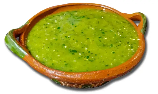 A bowl of vibrant green salsa with visible cilantro and chili pieces.